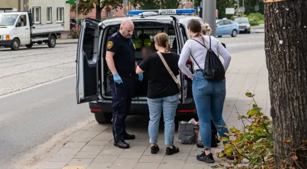 Strażnik miejski rozmawia z kobietami obok radiowozu. Może to być interwencja dotycząca zakłócania ciszy nocnej, wezwanie policji było konieczne.