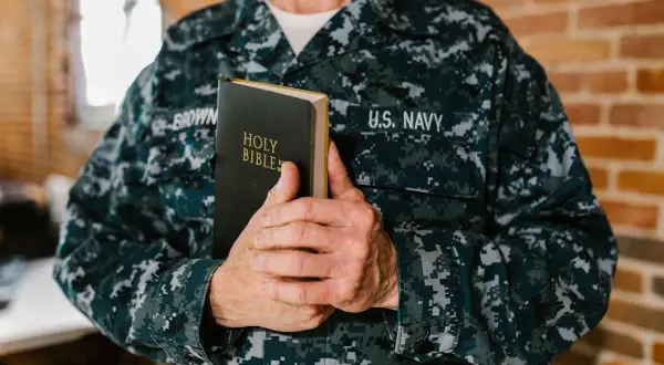 Marynarz US Navy trzyma Biblię. Może to być jego osobista pieśń nad pieśniami interpretacja wiary.