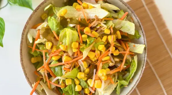 Ensalada china fresca con lechuga, zanahoria rallada, maíz y brotes.