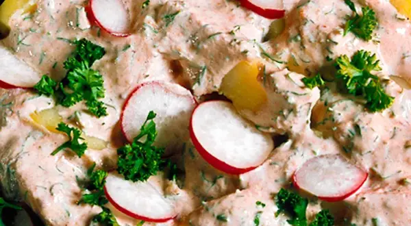 En krämig potatissallad med skivade rädisor och färska örter. Den här ser ut att vara den godaste potatissalladen någonsin!