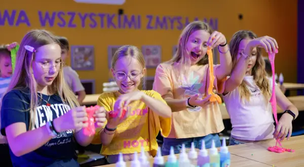 Dzieci tworzą slime, świetne atrakcje na Dzień Dziecka. Radość i kreatywność w kolorowym świecie zabawy.