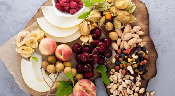 Ett uppdukat fat med frukt, bär och nötter – perfekt för ett nyttigt fika på jobbet. Här finns hallon, physalis, körsbär, nektariner, melon, bananchips, longan och en blandning av nötter och torkad frukt.