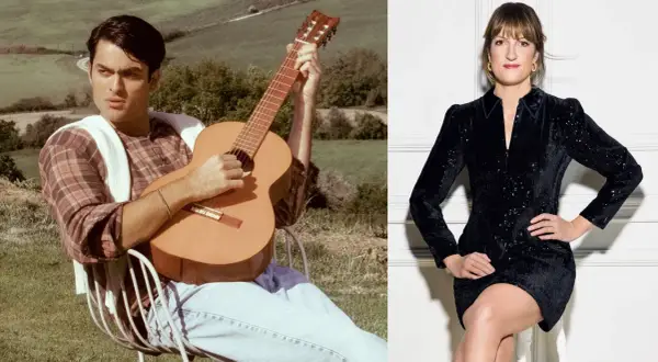 Mężczyzna gra na gitarze w plenerze, kobieta w czarnej sukience siedzi.