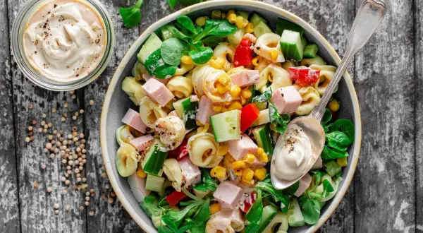 Najlepsza sałatka z tortellini: pyszne połączenie makaronu, szynki, kukurydzy, ogórka i papryki, polane kremowym sosem. Idealna na każdą okazję!