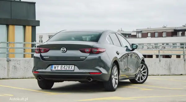 Szary sedan Mazda 3 na parkingu. Sprawdzamy mazda 3 spalanie i wrażenia z jazdy.