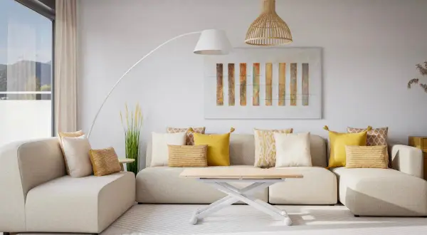 Sofá modular beige con cojines amarillos y blancos, mesa de centro blanca, lámpara de pie y cuadro abstracto. Un espacio acogedor sin ruido visual.