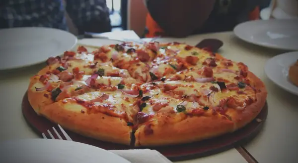 Pyszna, gorąca pizza z kurczakiem i cebulą, idealna do odgrzania. Smacznego!