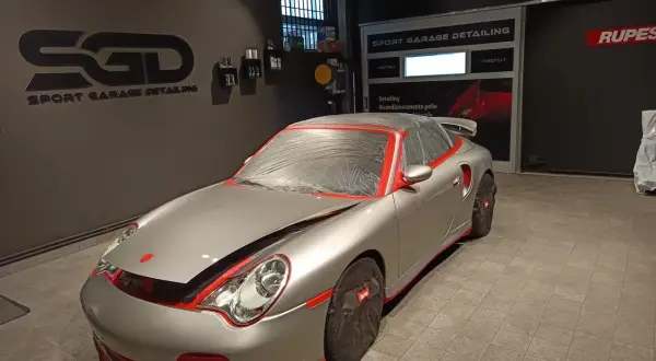 Auto sportiva pronta per il detailing. La carrozzeria è coperta per proteggerla durante il processo di come lucidare la macchina.