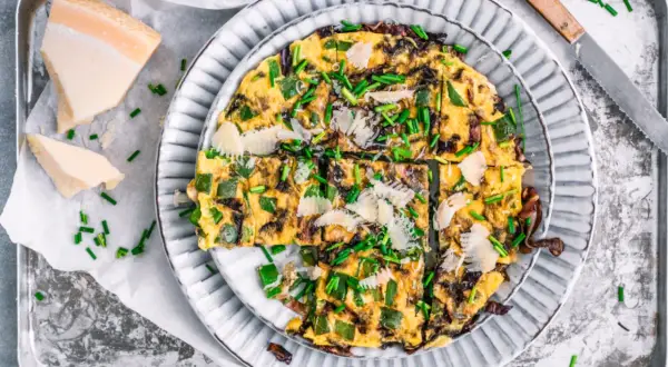 Herzhafte Frittata mit Paprika, Zwiebeln und Parmesan, garniert mit Schnittlauch. Perfekt für schnelle 15 Minuten Rezepte.