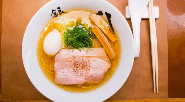 Misternie przygotowane ramen z plastrami wieprzowiny, jajkiem i szczypiorkiem. Zastanawiasz się, ile kalorii ma ramen?