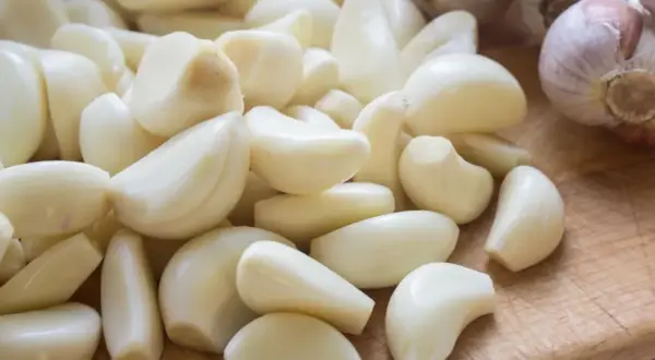 Stos czosnku, naturalny sposób na ziemiórki. Ząbki czosnku gotowe do użycia w ogrodzie.