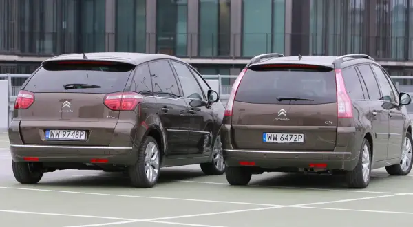 Dwa brązowe Citroen Picasso stoją obok siebie na parkingu.