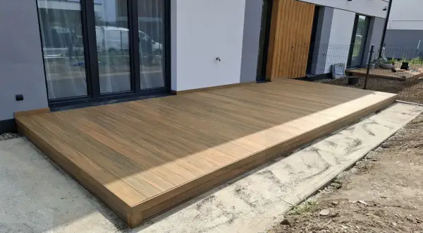 Nowy taras na słupach betonowych, wykonany z desek kompozytowych, stanowi idealne miejsce do wypoczynku.