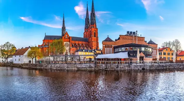 Uppsala domkyrka och stadsteatern speglar sig i Fyrisån. En vacker vy av vad det finns att se i Uppsala.