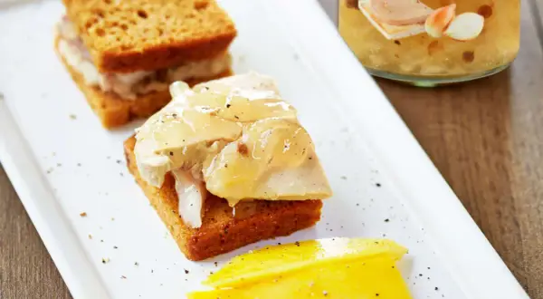 Toast de pain d'épice garni de foie gras et de confit d'oignons, accompagné de mangue.