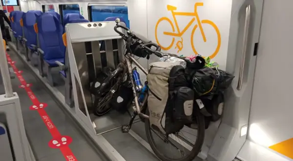 Rower w pociągu, gotowy na przygodę. Wygodne siedzenia i miejsce dla pasażerów z bagażem.