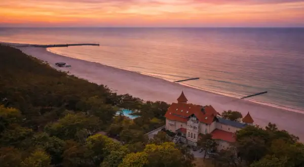 Zachód słońca nad Bałtykiem, idealne miejsce, gdzie na wakacje w Polsce. Piękna plaża, las i zabytkowy budynek z basenem.