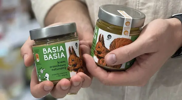 Dwie słoiki kremu orzechowego "Basia Basia" z wiewiórką na etykiecie. Czy masło orzechowe jest zdrowe? Ten naturalny krem z orzechów ziemnych odpowiada.