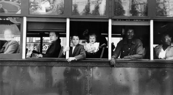 Dzieci i dorośli patrzą z okien tramwaju, uchwyceni okiem Roberta Franka.