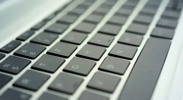 Zbliżenie na klawiaturę laptopa z widocznymi klawiszami liter i cyfr.
