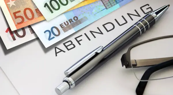 Euro-Scheine liegen auf einem Dokument mit dem Wort "ABFINDUNG". Ein Stift und eine Brille deuten auf eine bevorstehende Entscheidung oder Vereinbarung hin, vielleicht eine Abfindung nach 4 Jahren.