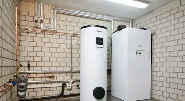 Nowoczesny zasobnik do pieca gazowego marki Vaillant obok kotła. Instalacja grzewcza w kotłowni.