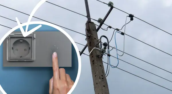 Ręka naciska przycisk obok gniazdka, sugerując koszt instalacji elektrycznej. W tle słup energetyczny z przewodami.