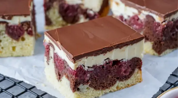 Saftiger Schneewittchenkuchen vom Blech mit Kirschen, Schokoglasur und cremiger Schicht. Ein Genuss für jeden Anlass!