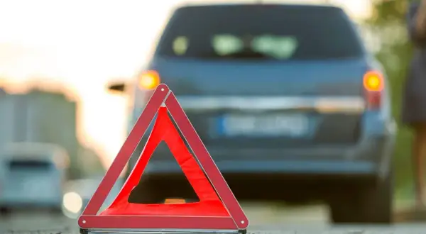 Warnblinker leuchten, ein rotes Warndreieck steht auf der Fahrbahn. Ein Auto ist liegen geblieben, ein abkommen von der fahrbahn ist nicht zu sehen.