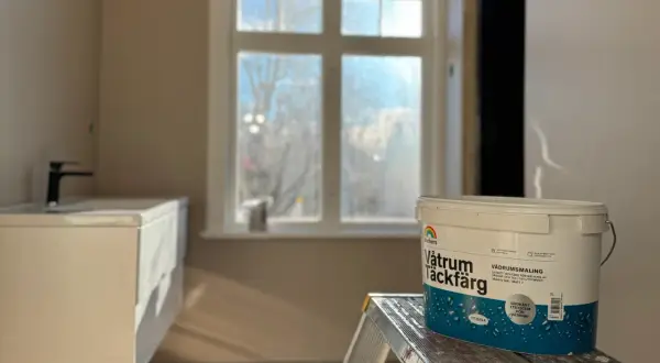 En hink med Beckers Våtrum Täckfärg står på en stege i ett badrum under renovering. Följ regler för att måla i badrum.