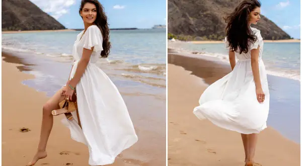Kobieta w zwiewnej, białej sukience spaceruje po plaży. Idealne biała sukienka stylizacje na wakacje.