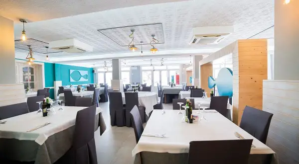 Mesas puestas en el restaurante Blanca Brisa Cabo de Gata. Ambiente marino con decoración de peces.