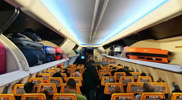 Wnętrze samolotu Ryanair, bagaże na półkach. Gdzie znajdę numer lotu Ryanair? Na ekranach przed siedzeniami.