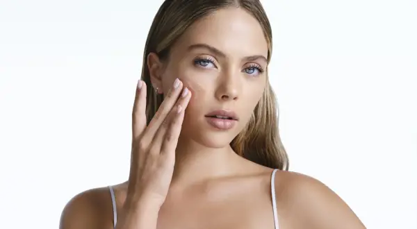 Frau trägt ein Serum auf, das die Haut mit Feuchtigkeit versorgt, um zu verhindern, dass Retinol die Haut austrocknet.