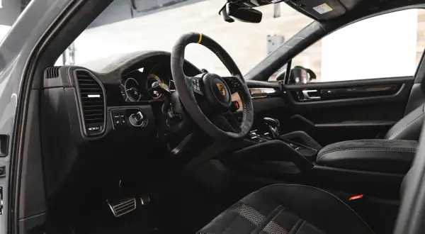 Luksusowe detailing wnętrza Porsche: skórzana kierownica, sportowe fotele z alcantary i nowoczesna deska rozdzielcza.