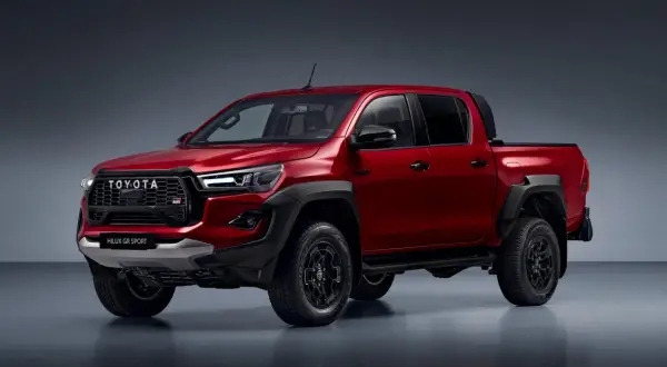 Czerwony Toyota Hilux GR Sport z czarnymi dodatkami i felgami, gotowy na każdą przygodę.