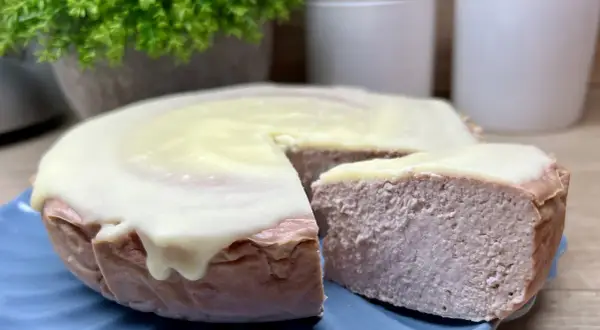 Pyszny sernik z malinami, oblany kremowym lukrem, kusi swoim wyglądem. Idealny na deser.
