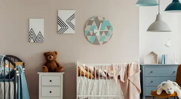 Chambre de bébé avec berceau, peluche et horloge géométrique. Une belle idée de diy deco bebe pour une chambre douce et moderne.