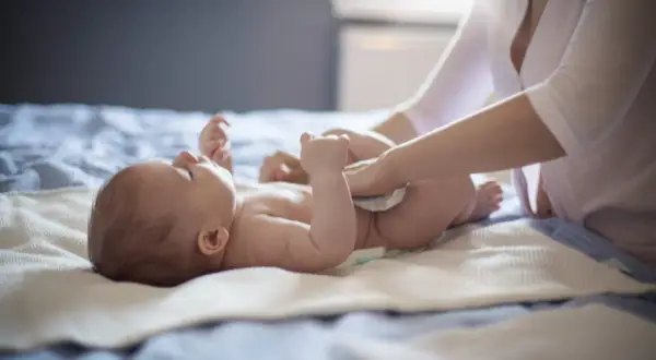 Mama zmienia pieluszkę niemowlaka, który ma biegunkę.