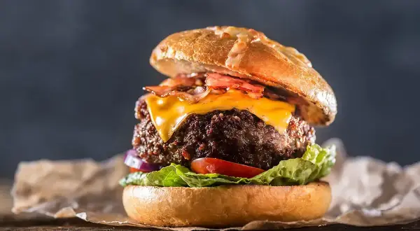 En saftig hamburgare med ost och bacon, perfekt för att grilla hamburgare en sommarkväll.