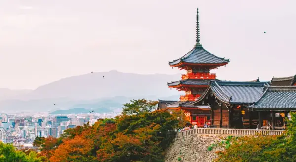 Widok na pagody i tradycyjną architekturę w Kioto, które kiedyś było stolicą Japonii. W tle rozciąga się miejski krajobraz.