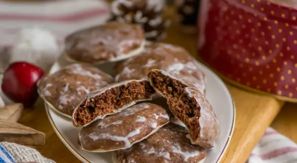 Saftige Lebkuchen, perfekt für jedes Lebkuchen Rezept. Einer ist aufgeschnitten und zeigt die feine Krume.