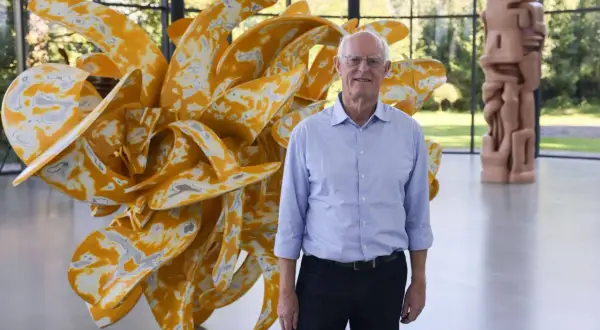 Tony Cragg in Wuppertal vor seiner gelben Skulptur. Im Hintergrund eine weitere Skulptur.