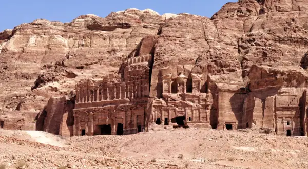 Ancient rock-cut tombs and facades carved into a sandstone cliff face in Petra, Jordan.