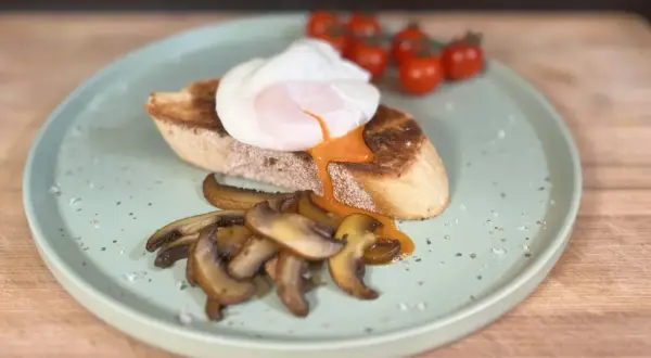 Un huevo poche perfecto sobre tostada con champiñones y tomates. ¡Así se hacen huevos poche deliciosos!