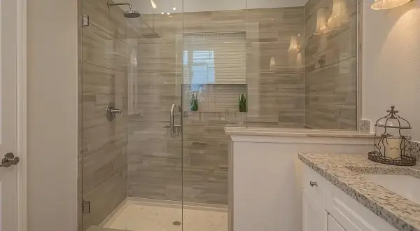 A modern bathroom featuring a spacious glass-enclosed shower with wood-look tile walls, a testament to a successful DIY shower tile installation.