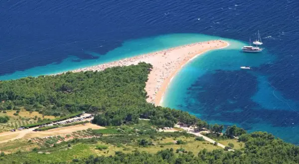 Zloty piasek i turkusowa woda na plaży w Chorwacji. Idealne miejsce na wakacje, pomyśl o bezpośrednie loty do chorwacji!