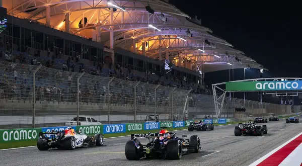Wyścig F1 nocą. Kierowcy walczą o cenne f1 punkty, ścigając się pod oświetloną trybuną.