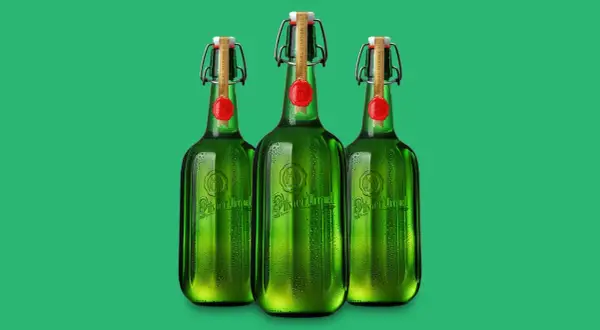 Drei grüne Flaschen Pilsner Urquell mit Bügelverschluss und rotem Siegel stehen nebeneinander.