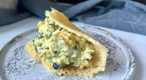 Pyszna pasta z awokado i jajka, podana w chrupiącej wafelkowej łódeczce. Idealna na szybką przekąskę.